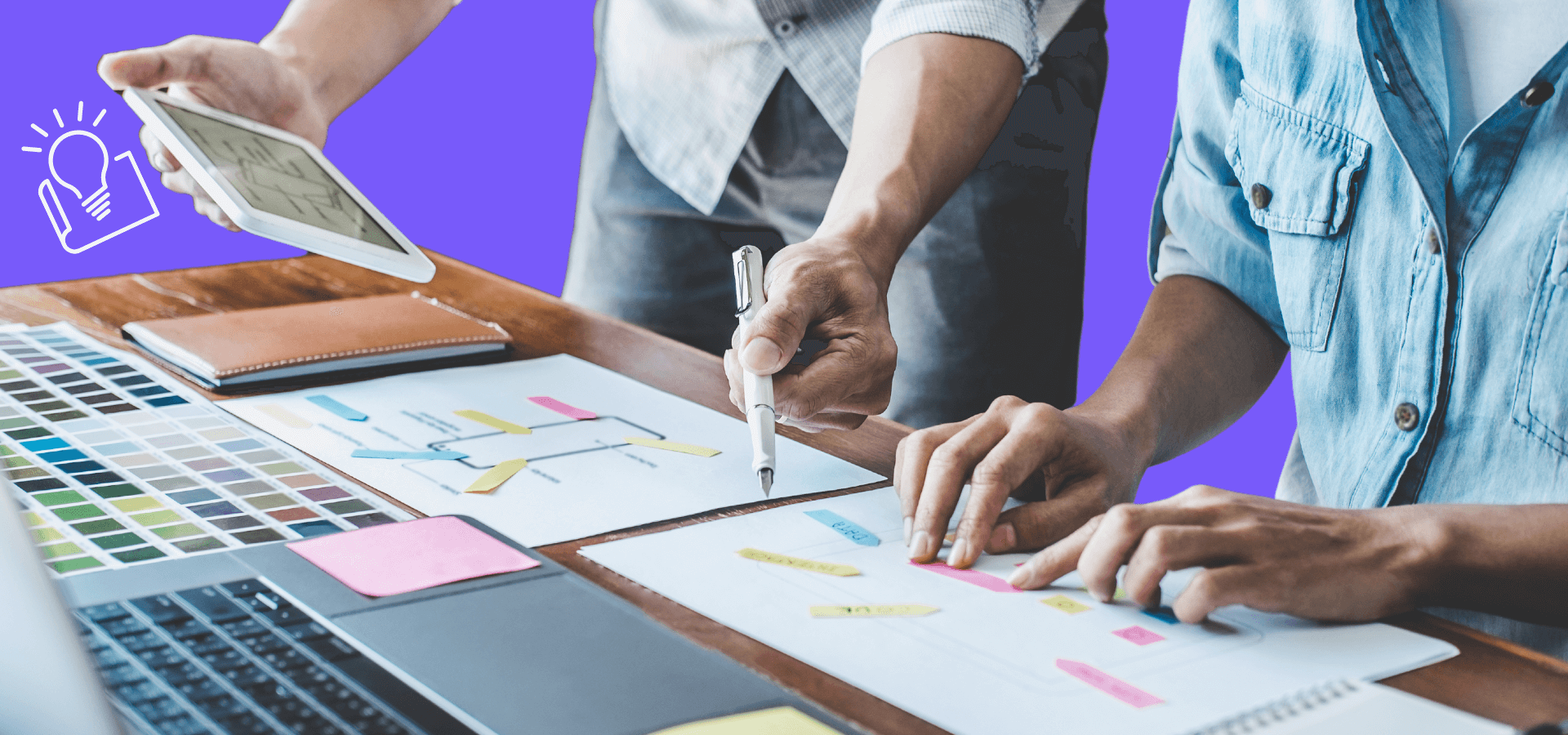 Two sets of hands working on a plan at a table