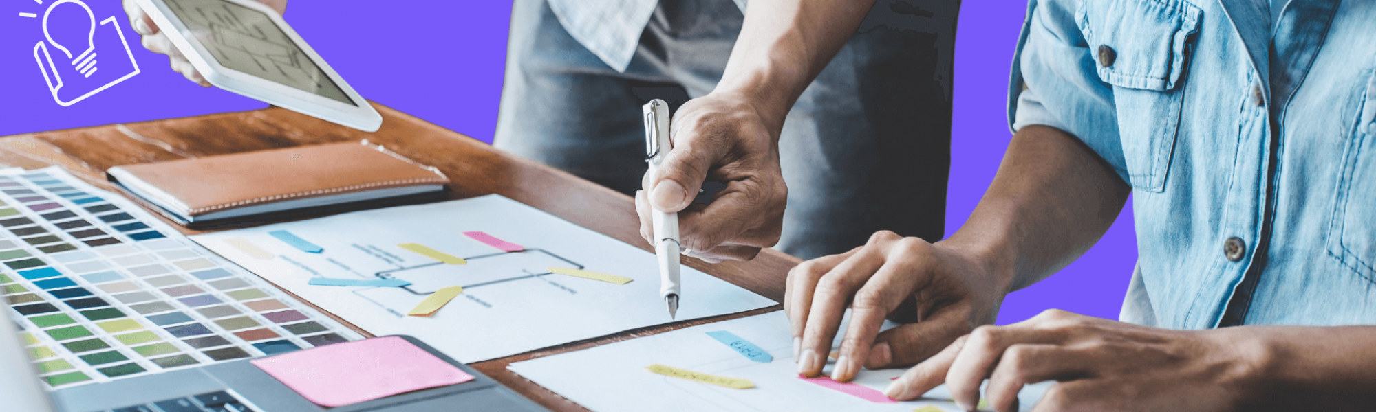 Two sets of hands working on a plan at a table